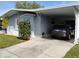 View of the home's carport with parking and landscaping at 34135 Brown Bayou, Wesley Chapel, FL 33543