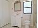 Bathroom with window, framed mirror, and white vanity at 3622 Cheswick Dr, Holiday, FL 34691