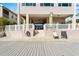 Home exterior showcasing stairs leading to a screened-in porch, with a white fence and sitting area at 4058 Centavo Ct, Hernando Beach, FL 34607