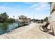 Backyard dock area showing boat lift, seating, and canal access with clear skies at 4058 Centavo Ct, Hernando Beach, FL 34607