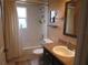 This bathroom features a tiled shower-tub combo and brown vanity with a sink and granite countertop at 4096 Everett Ave, Spring Hill, FL 34609