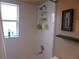 This bathroom features a tiled shower with shelving and a large window for natural light at 4096 Everett Ave, Spring Hill, FL 34609