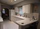 Kitchen with white cabinets, countertops, and appliances with tile floors, plus view to dining room at 4096 Everett Ave, Spring Hill, FL 34609