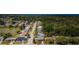 Aerial view of a residential neighborhood with a lake and the ocean in the distance surrounded by lush greenery at 4107 Glissade Dr, New Port Richey, FL 34652