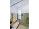 Bathroom featuring green tile, a built-in bench in the shower, and a window for natural light at 4107 Glissade Dr, New Port Richey, FL 34652