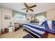 Bright bedroom with a blue and white striped bed, complemented by a ceiling fan and natural light at 4107 Glissade Dr, New Port Richey, FL 34652