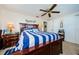 Comfortable bedroom featuring a striped bed, dark wood furniture, and plenty of natural light at 4107 Glissade Dr, New Port Richey, FL 34652