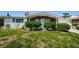 Charming home with brick accents, complemented by a well-manicured front yard, shrubs, and a vibrant flag at 4107 Glissade Dr, New Port Richey, FL 34652
