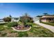Home featuring white siding, brick details, and a landscaped front yard, framed by a blue sky at 4107 Glissade Dr, New Port Richey, FL 34652