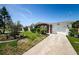 Front yard of a home with mature trees and flowering shrubs and a walkway leading to the front door at 4107 Glissade Dr, New Port Richey, FL 34652