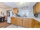 Bright eat-in kitchen with wood cabinets and view into an adjacent dining room at 4107 Glissade Dr, New Port Richey, FL 34652