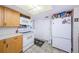 Bright kitchen with white appliances, wood cabinets, and a closet with sliding doors at 4107 Glissade Dr, New Port Richey, FL 34652