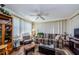 Cozy living room with comfortable plaid sofa, ceiling fan, and plenty of natural light at 4107 Glissade Dr, New Port Richey, FL 34652