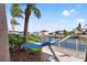 Waterfront backyard with a hammock strung between palm trees, creating a tranquil outdoor space at 4207 Carlos Ct, Hernando Beach, FL 34607