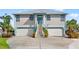 Charming two-story home with a metal roof, featuring double garages and an inviting entryway with painted accents at 4207 Carlos Ct, Hernando Beach, FL 34607