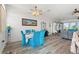 Open-concept living space showcasing wood floors, blue chairs, and plenty of natural light at 4207 Carlos Ct, Hernando Beach, FL 34607