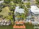An aerial view of a waterfront home with a private dock on a canal, surrounded by lush tropical trees at 4470 Kingston Dr, Hernando Beach, FL 34607