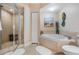 Bright bathroom featuring a glass shower, soaking tub, and decorative mermaid artwork at 4516 Seagull Dr # 509, New Port Richey, FL 34652