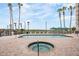 Community pool with hot tub and lounge seating surrounded by tall palm trees at 4516 Seagull Dr # 509, New Port Richey, FL 34652