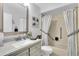 Well lit bathroom featuring a shower and tub combination with grab bars for accessibility at 4831 Wakefield Ct, New Port Richey, FL 34655