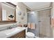 Bathroom featuring a sink with wood cabinetry and a shower with glass door and tan tile at 4831 Wakefield Ct, New Port Richey, FL 34655