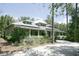 Spacious home featuring a metal roof, covered porch, and a tranquil setting amidst lush trees and natural landscaping at 4831 Wakefield Ct, New Port Richey, FL 34655