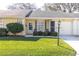 Charming single-story home with a well-manicured lawn and quaint front porch seating area at 4831 Wakefield Ct, New Port Richey, FL 34655