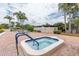Inviting hot tub with surrounding lounge area, palm trees, and well-maintained brick patio at 4831 Wakefield Ct, New Port Richey, FL 34655