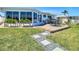 Backyard featuring a deck, walkway, and sunroom, enhanced by lush grass at 4936 Dory Dr, New Port Richey, FL 34652