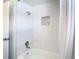 Close up of tiled shower with tub, showerhead, and recessed shower niche at 4936 Dory Dr, New Port Richey, FL 34652