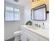 Bathroom with a modern vanity, black framed mirror, and window with valance at 4936 Dory Dr, New Port Richey, FL 34652