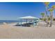 Relaxing beachfront with shade structures, picnic tables, calm water and clear blue sky at 4936 Dory Dr, New Port Richey, FL 34652