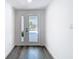 Bright and modern foyer with light-colored walls, a view to the front yard, and hardwood floors at 4936 Dory Dr, New Port Richey, FL 34652