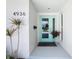Inviting front door with a turquoise frame, complemented by elegant potted plants, and updated hardware at 4936 Dory Dr, New Port Richey, FL 34652