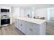 Kitchen island with white countertop, gray cabinets, and stainless steel hardware at 4936 Dory Dr, New Port Richey, FL 34652