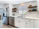 Modern kitchen features bright, subway tile, quartz countertops, floating shelves, and stainless-steel appliances at 4936 Dory Dr, New Port Richey, FL 34652