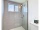 The new glass enclosed shower features gray subway tile and pebble floor at 4936 Dory Dr, New Port Richey, FL 34652