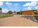 Inviting exterior showcasing a concrete driveway, neutral stucco, and ample yard space under a partly cloudy sky at 5000 Southshore Dr, New Port Richey, FL 34652