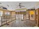 Open living area with tile floors, modern ceiling fans, and wall and plumbing under construction at 5000 Southshore Dr, New Port Richey, FL 34652
