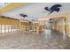 Open living area with tile floors, modern ceiling fans, and wall and plumbing under construction at 5000 Southshore Dr, New Port Richey, FL 34652