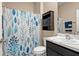 Bathroom featuring a blue patterned shower curtain, a modern vanity, and a storage cabinet at 582 8Th Nw St, Ruskin, FL 33570
