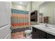 Bright bathroom featuring a marble countertop and modern cabinet, alongside a colorful shower curtain at 582 8Th Nw St, Ruskin, FL 33570
