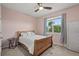 Cozy bedroom with a wooden bed frame, neutral walls, and a bright window at 582 8Th Nw St, Ruskin, FL 33570