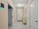 Well-lit hallway featuring tile flooring, a decorative cabinet, and access to multiple rooms at 582 8Th Nw St, Ruskin, FL 33570