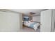 Bedroom featuring a ceiling fan, window, and large closet with sliding doors at 7024 Coral Reef Dr, Port Richey, FL 34668