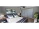 Relaxing bedroom with a ceiling fan, large windows, light gray walls, plush bedding, and spacious closet at 7024 Coral Reef Dr, Port Richey, FL 34668