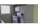 Cozy kitchen featuring updated white appliances, dark cabinets, and natural light from the window at 7024 Coral Reef Dr, Port Richey, FL 34668