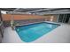 Inviting covered pool featuring a rock waterfall, privacy fence and cool deck at 7024 Coral Reef Dr, Port Richey, FL 34668