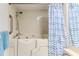 Well-lit bathroom features a walk-in tub, and white tiled walls with blue accents at 7107 Pond View Ct, Spring Hill, FL 34606
