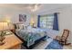 Bright bedroom featuring stylish decor, a window with outdoor views, and a light colored wood-look floor at 7107 Pond View Ct, Spring Hill, FL 34606
